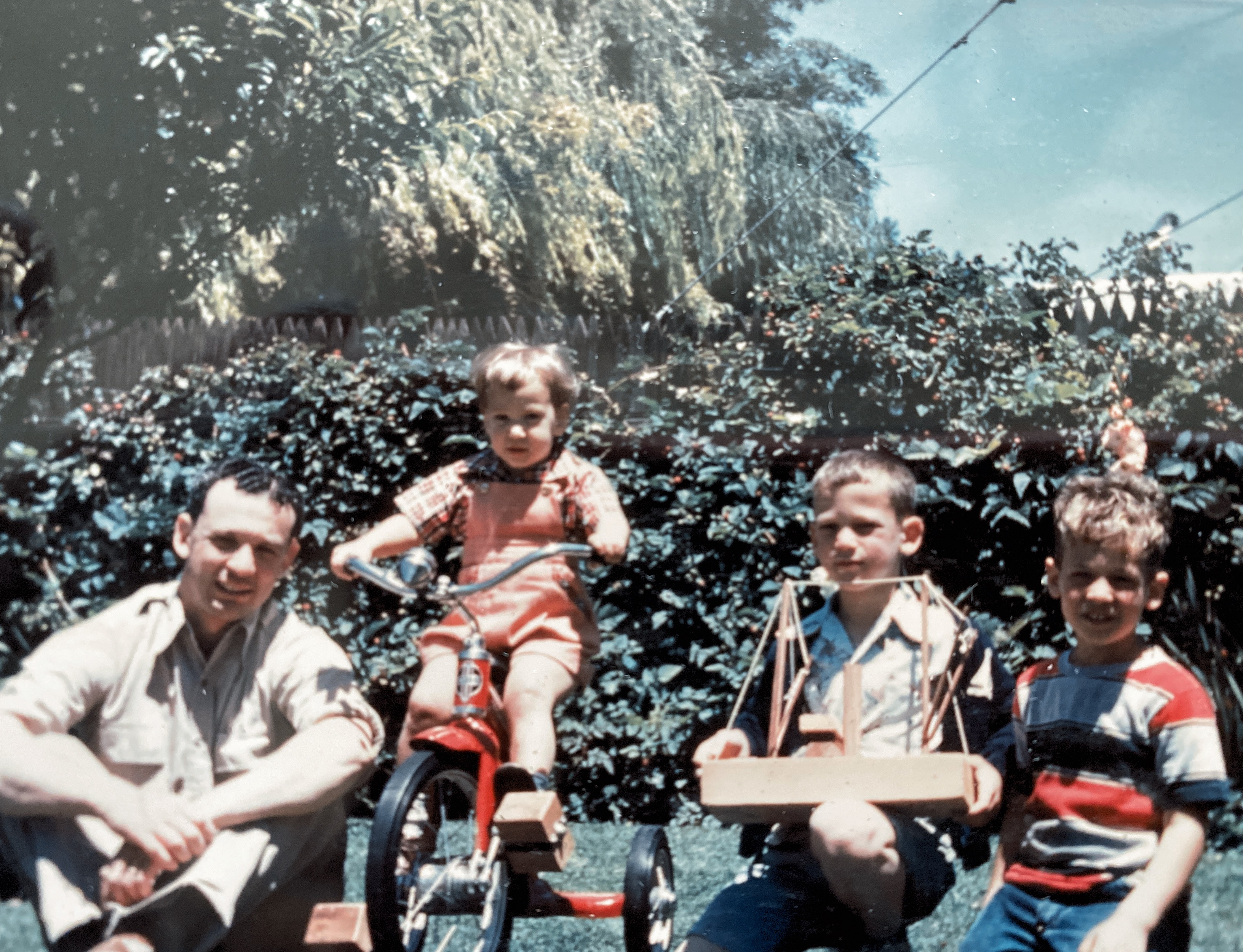 Dad, me, Kenny, and a neighbor friend in our backyard. 1951