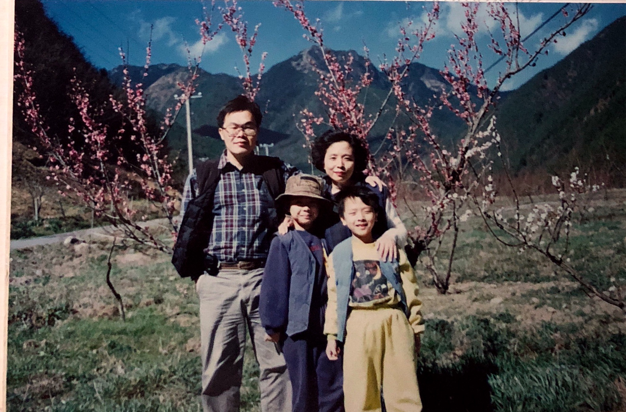 這張照片是20年前孩子剛放寒假的第一天，我們全家到武陵農場旅遊的照片，當天天氣非常的好，艷陽高照，梅花朵朵開，照片裡的家人，個個綻開笑容。